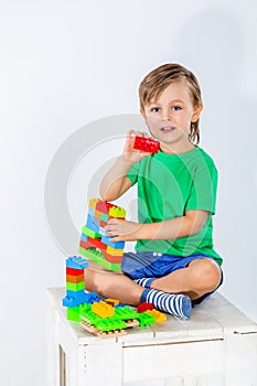 Little boy playing with lots of colorful plastic blocks constructor .