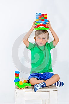 Little boy playing with lots of colorful plastic blocks constructor .