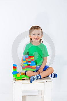 Little boy playing with lots of colorful plastic blocks constructor .