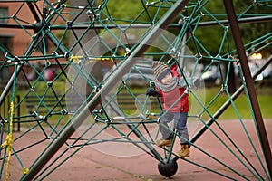 Little boy playing on modern kids play ground