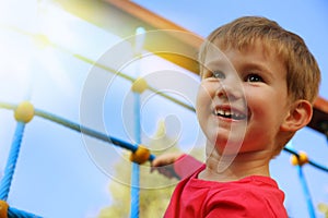 Little boy playing on monkey bars