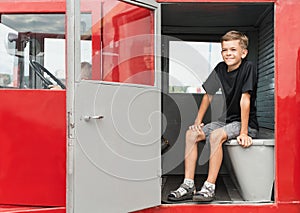 A little boy is playing near a car