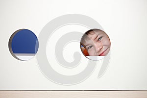Little boy playing peek-a-boo smiling