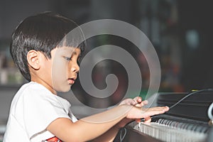 Little Boy playing with piano and Music Tablet at home