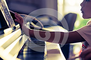 Little Boy playing with piano and Music Tablet at home