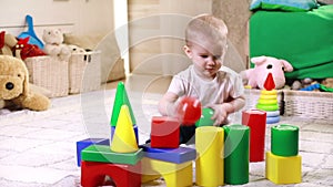 Little boy playing with plastic blocks