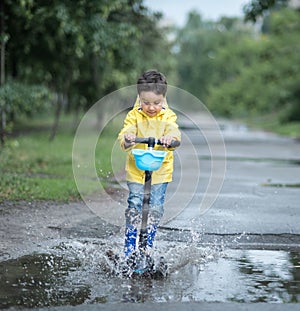 Little boy playing in puddle