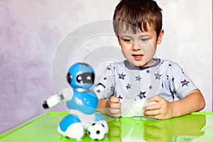 Little boy is playing with robot. Robot for children. Smart toy