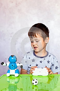 Little boy is playing with robot. Robot for children. Smart toy