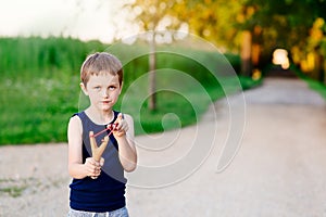 Little boy playing with slingshot