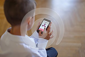 Little boy playing on smartphone spinner