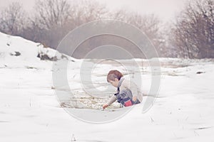 Little boy playing in the snow