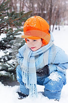 Little boy playing snowballs, snowman sculpts photo