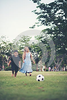 Little boy playing soccer football with mother
