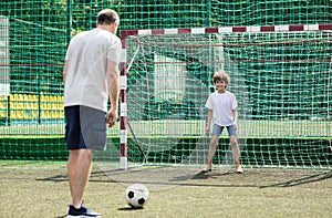 Little boy playing soccer with his father