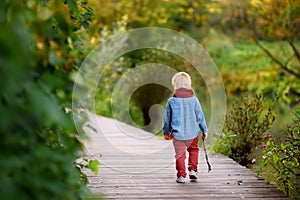 Little boy playing during stroll in the forest