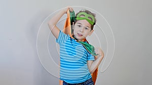 Little boy playing a superhero. Kid in an Superhero`s costume. happy child. green mask, nature care concept