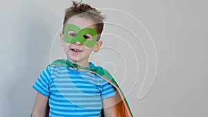 Little boy playing a superhero. Kid in an Superhero`s costume. happy child. green mask, nature care concept