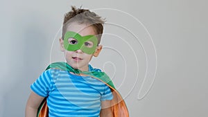 Little boy playing a superhero. Kid in an Superhero`s costume. happy child. green mask, nature care concept