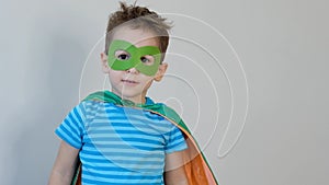 Little boy playing a superhero. Kid in an Superhero`s costume. happy child. green mask, nature care concept