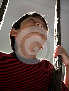 Little boy playing swing indoor rim light