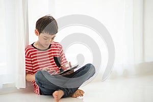 Little boy playing tablet at home