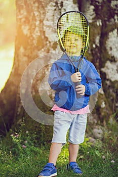 Little boy playing tennis at park