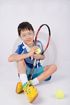 Little boy playing tennis racket and tennis ball in hand