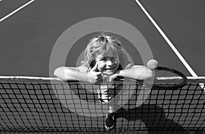 Little boy playing tennis. Sport kids, thumbs up, winner. Child with tennis racket on tennis court. Training for young