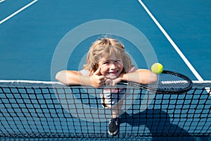 Little boy playing tennis. Sport kids, thumbs up, winner. Child with tennis racket on tennis court. Training for young