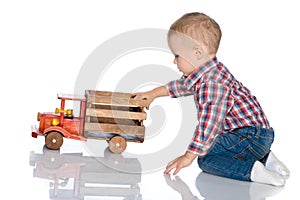 A little boy is playing with a toy car.