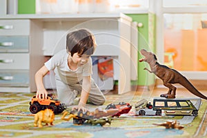 Little boy playing toy cars on play mat. Young kid with colorful educational vehicle and transport toys on carpet. City street map