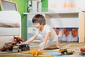 Little boy playing toy cars on play mat. Young kid with colorful educational vehicle and transport toys on carpet. City