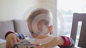 Little boy playing toy model car at the table