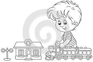 Little boy playing with a toy train in a playroom