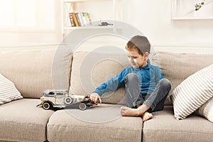 Little boy playing with toy car at home