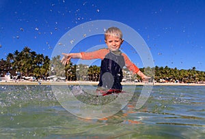 Little boy playing with water on the beach