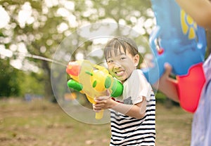 little boy playing with water guns on summer