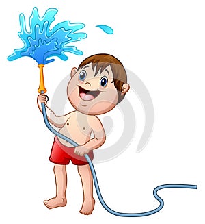 Little boy playing with the water hose