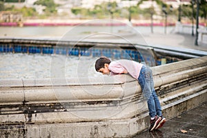 Little boy playing water over fountain outdoor