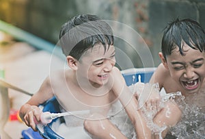 Little boy playing water splash at the backyard outdoor activities summer time