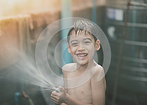 Little boy playing water splash at the backyard outdoor activities summer time