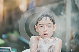 Little boy playing water splash at the backyard outdoor activities summer time