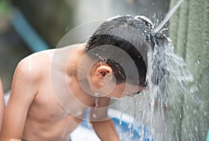 Little boy playing water splash at the backyard outdoor activities summer time