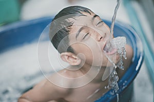 Little boy playing water splash at the backyard outdoor activities summer time