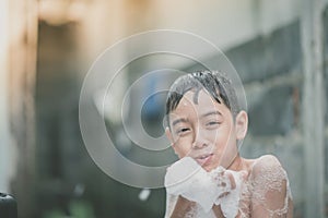 Little boy playing water splash at the backyard outdoor activities summer time