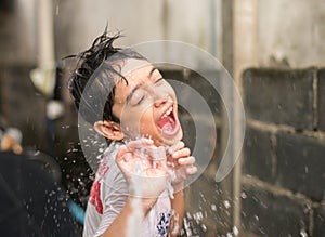 Little boy playing water splash over face