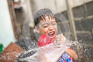 Little boy playing water splash over face