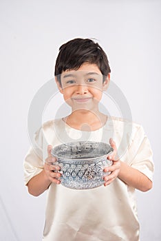 Little boy playing water on water festival Thailand new year with hand