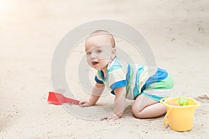 A little boy playing on a white sand. Child with toys for the sa